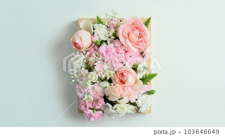 Wooden crate full of pastel colors flowers with pink rose and carnation on white background 103646649