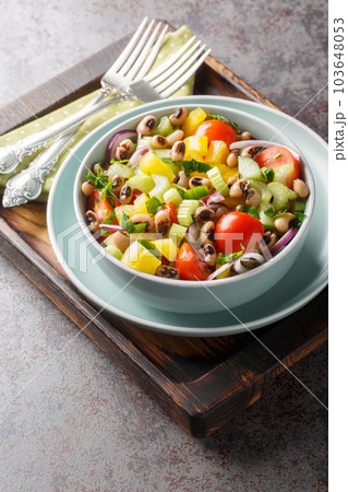 Fresh salad with cherry tomatoes, celery, yellow pepper, black-eyed peas, cucumber and onion close-up in a bowl. Vertical Fresh salad with cherry tomatoes, celery, yellow pepper, black-eyed peas, cucumber and onion close-up in a bowl. Vertical 103648053