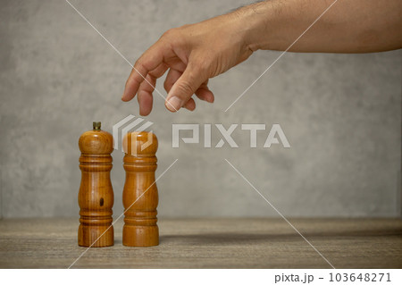 塩コショウ入れと、それを持つ男性の手 103648271