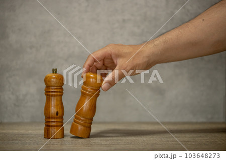 塩コショウ入れと、それを持つ男性の手 103648273