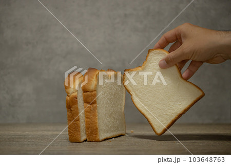 食パンと手　スライスした食パンを手に取る男性の手　 103648763