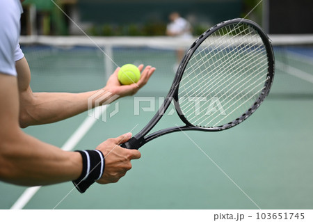 Cropped image of male tennis player with racket serving ball during match Cropped image of male tennis player with racket serving ball during match 103651745