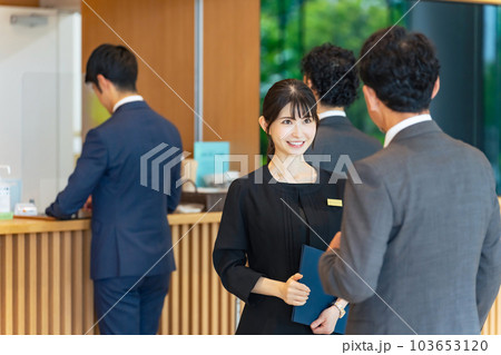 フロントで旅行客を接客する案内係の女性 フロントで旅行客を接客する案内係の女性 103653120