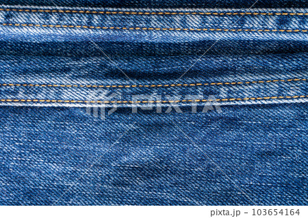 Blue denim with seams and light stains close up Blue denim with seams and light stains close up 103654164