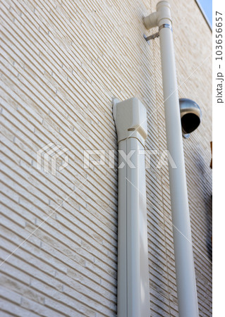 一戸建て住宅の外壁に取り付けてあるエアコンのドレーンと竪樋 一戸建て住宅の外壁に取り付けてあるエアコンのドレーンと竪樋 103656657
