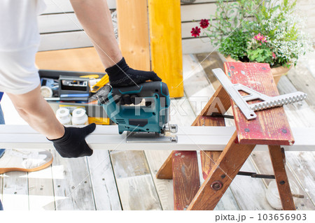 DIYでジグソーを使って作業する男性 DIYでジグソーを使って作業する男性 103656903