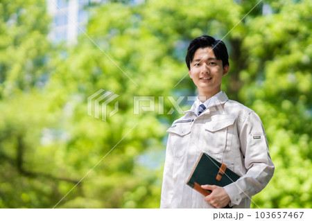 新緑中手帳を持って歩くエンジニア 103657467