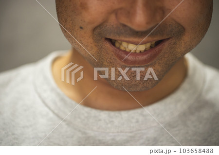 怪しげにほほ笑む男性　歯を出して笑う髭の濃い中年男性 103658488