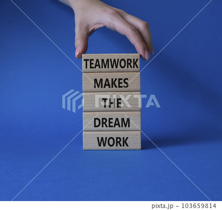 Teamwork symbol. Wooden blocks with words Teamwork makes the Dream work. Businessman hand. Beautiful blue background. Business and Teamwork makes the Dream work concept. Copy space. 103659814