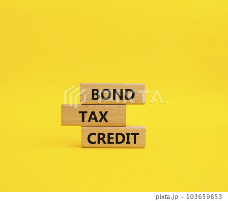 Bond Tax Credit symbol. Concept word Bond Tax Credit on wooden blocks. Beautiful yellow background. Business and Bond Tax Credit concept. Copy space Bond Tax Credit symbol. Concept word Bond Tax Credit on wooden blocks. Beautiful yellow background. Business and Bond Tax Credit concept. Copy space 103659853