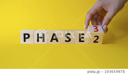 From Phase 2 to 3 symbol. Businessman Hand turns cubes and changes words Phase 2 to Phase 3. Beautiful yellow background. Business and Phase concept. Copy space From Phase 2 to 3 symbol. Businessman Hand turns cubes and changes words Phase 2 to Phase 3. Beautiful yellow background. Business and Phase concept. Copy space 103659978
