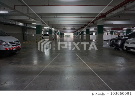 Photo of car and motorbike parking in the basement of a building, late afternoon 103660091