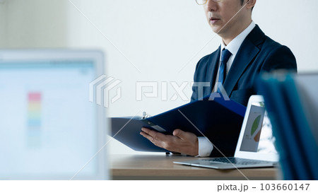 資料に目を通すビジネスマン 資料に目を通すビジネスマン 103660147