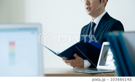資料に目を通すビジネスマン 103660148