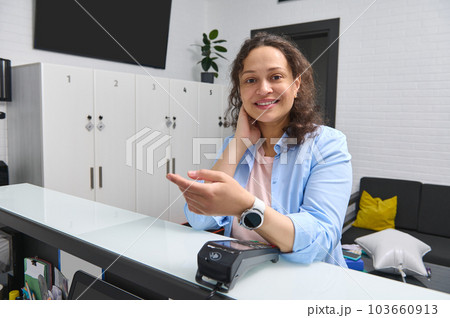 Happy smiling woman, customer, client paying by smart wristwatch using NFC technology. 103660913