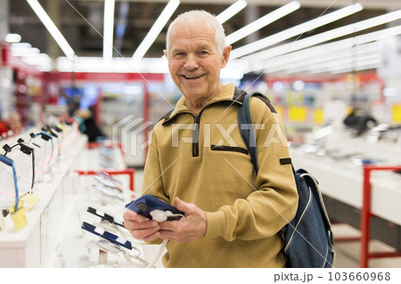 senor man pensioner buying modern tablet digital in showroom of digital electronic goods store 103660968