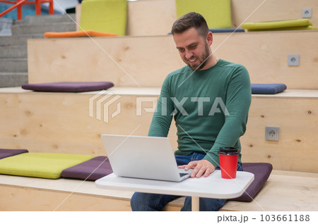 Caucasian man working on laptop in coworking space. Open space. Caucasian man working on laptop in coworking space. Open space. 103661188