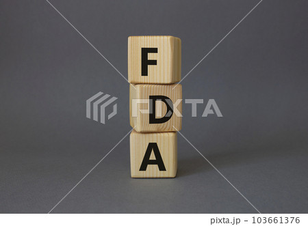 FDA - Food Drug Administration symbol. Wooden cubes with word FDA. Beautiful grey background. Medical and Food Drug Administration concept. Copy space. 103661376