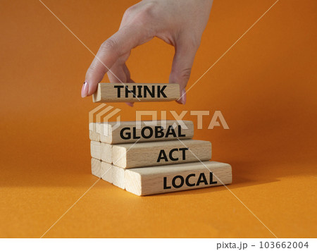 Think global act local symbol. Wooden blocks with words Think global act local. Beautiful orange background. Businessman hand. Business and Think global act local concept. Copy space. 103662004
