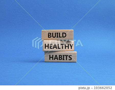 Healthy habits symbol. Concept word Build Healthy habits on wooden blocks. Beautiful blue background. Healthy lifestyle and Healthy habits concept. Copy space 103662052