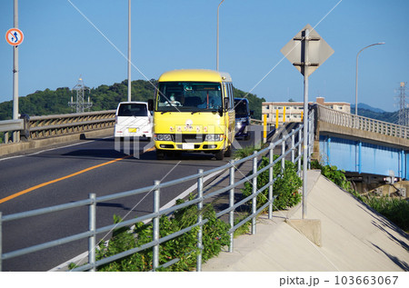 黄色の車体の広域生活バスが道路を走っている光景 103663067