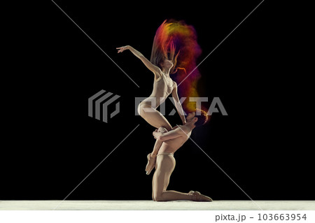 Expressive dance. Young man and woman, ballet dancers making performance with powder explosion against black studio background Expressive dance. Young man and woman, ballet dancers making performance with powder explosion against black studio background 103663954
