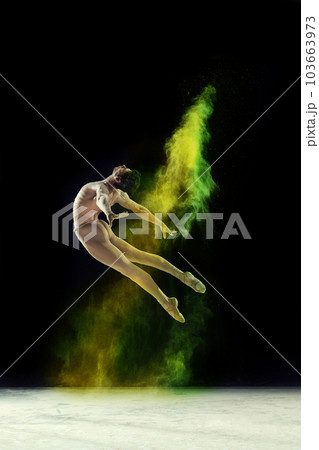 Muscular young man, professional ballet dancer in motion, dancing with colorful powder explosion against black studio background Muscular young man, professional ballet dancer in motion, dancing with colorful powder explosion against black studio background 103663973