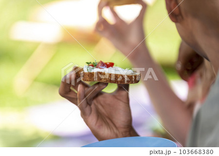 man is holding an appetizer in his hand 103668380