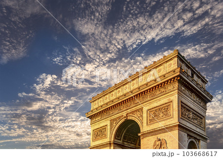 Arc de Triomphe (against the background of sky with clouds), Paris, France. The walls of the arch are engraved with the names of 128 battles and names of 660 French military leaders (in French) 103668617