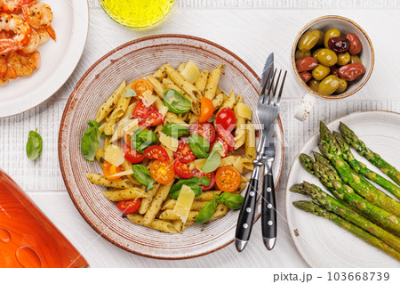 Italian pasta adorned with fresh tomatoes and aromatic basil Italian pasta adorned with fresh tomatoes and aromatic basil 103668739