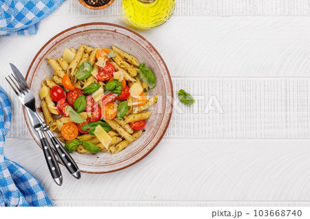 Italian pasta adorned with fresh tomatoes and aromatic basil Italian pasta adorned with fresh tomatoes and aromatic basil 103668740