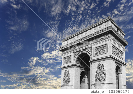 Arc de Triomphe (against the background of sky with clouds), Paris, France. The walls of the arch are engraved with the names of 128 battles and names of 660 French military leaders (in French) 103669173