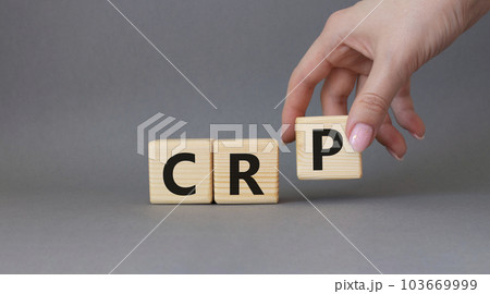 CRP - C-Reactive Protein Test symbol. Wooden cubes with word CRP. Doctor hand. Beautiful grey background. Medical and C-Reactive Protein Test concept. Copy space. 103669999
