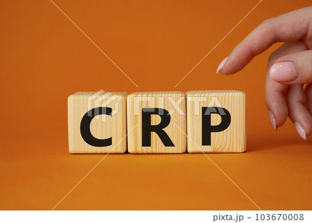 CRP - C-Reactive Protein Test symbol. Wooden cubes with word CRP. Doctor hand. Beautiful orange background. Medical and C-Reactive Protein Test concept. Copy space. 103670008