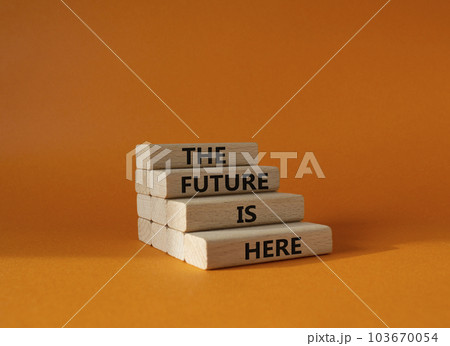 The future is here symbol. Concept words TThe future is here on wooden blocks. Beautiful orange background. Business and The future is here concept. Copy space. 103670054