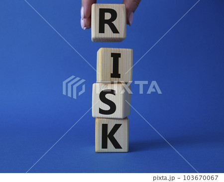Risk symbol. Concept word Risk on wooden cubes. Businessman hand. Beautiful blue background. Business and Risk concept. Copy space. 103670067