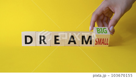Dream Big vs Small symbol. Businessman Hand turns cubes and changes words Dream Small to Dream Big. Beautiful yellow background. Business and Dream concept. Copy space 103670155