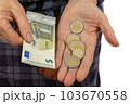 An old woman counts euro coins on her palm 103670558