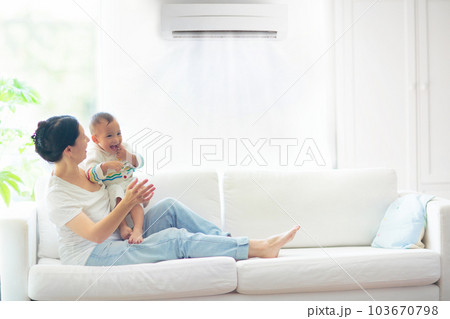 Mother and child with air conditioner remote Mother and child with air conditioner remote 103670798