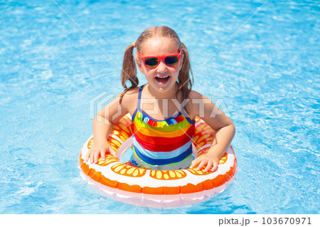 Child in swimming pool on toy ring. Kids swim. 103670971