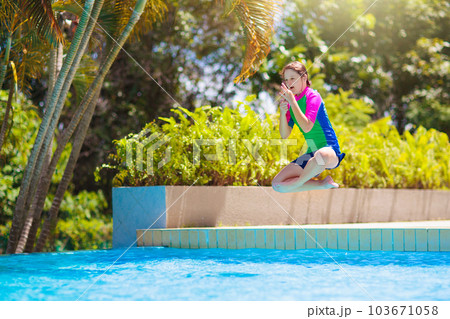 Kids jump into swimming pool. Summer water fun. Kids jump into swimming pool. Summer water fun. 103671058