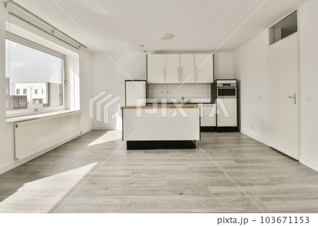 an empty kitchen and dining area in a house with white walls, wood flooring and large windows looking out onto the street an empty kitchen and dining area in a house with white walls, wood flooring and large windows looking out onto the street 103671153