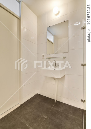 a bathroom with a sink and mirror on the wall next to an open door that leads to a walk - in shower 103671188
