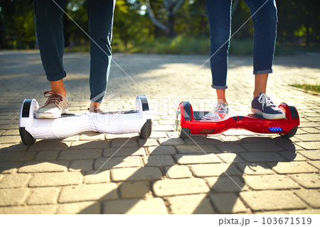 Legs of man and woman riding on the Hoverboard together outdoor. Active lifestyle technology future. 103671519