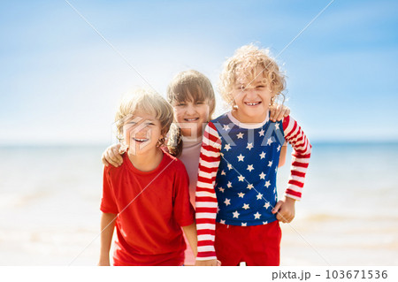 Kids with American flag on beach. 4th of July. 103671536