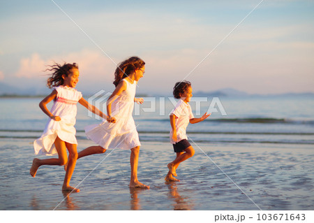 Child playing on ocean beach. Kid at sunset sea. 103671643