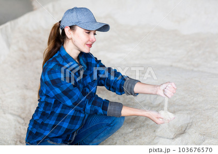 Woman farmer checking quality of maize flour 103676570