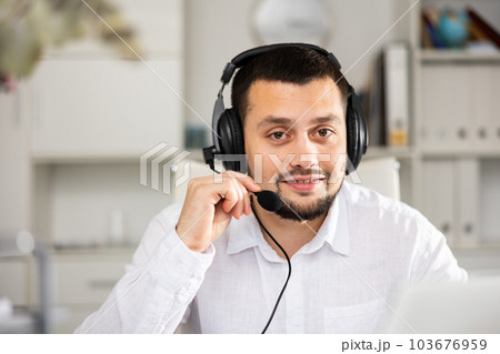 Portrait of positive man office worker wearing headset 103676959
