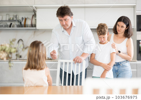 Father and mother telling off son and daughter for disobedience 103676975