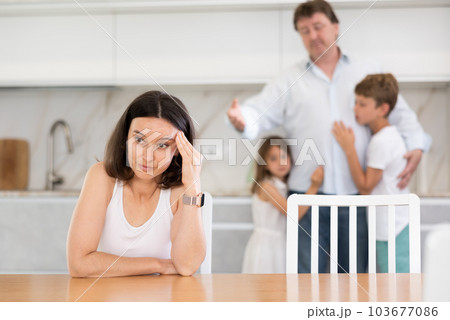 Offended mother sitting at the kitchen table Offended mother sitting at the kitchen table 103677086